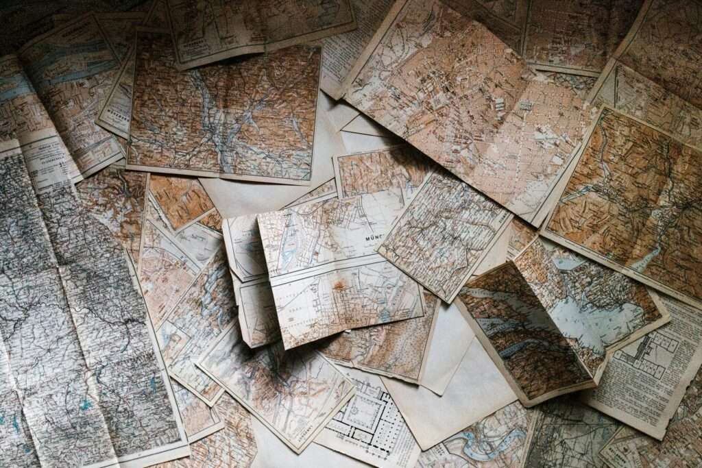 A collection of vintage maps scattered for exploring world journeys and discoveries.